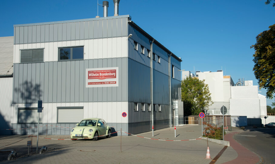 Gebäude von Wilhelm Brandenburg, graue Fassade mit Firmenschild