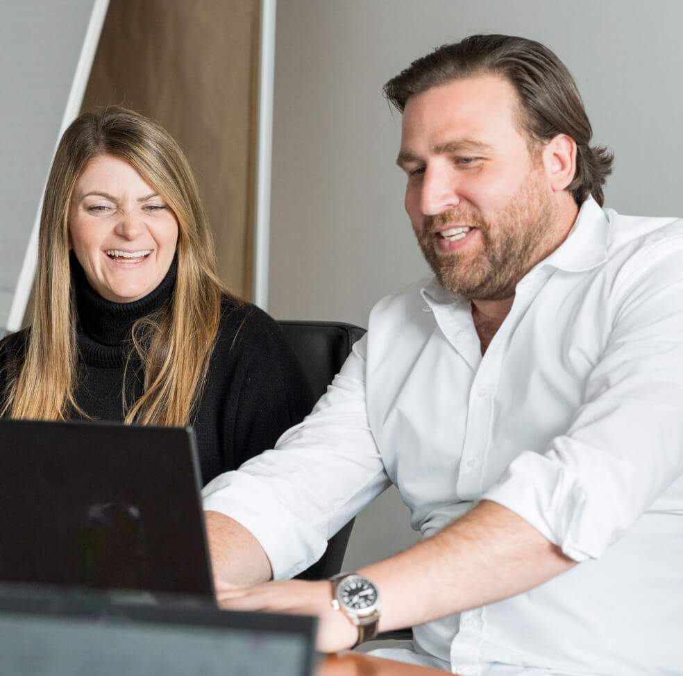 Teammitglieder arbeiten zusammen am Laptop bei Wilhelm Brandenburg