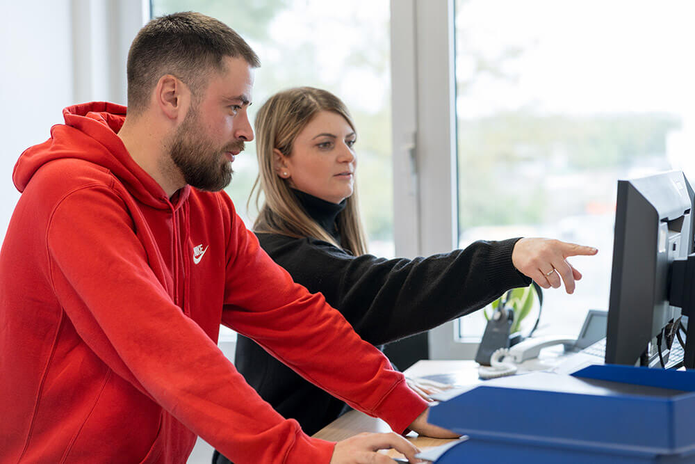 Mitarbeiterteam bei Wilhelm Brandenburg arbeitet gemeinsam am Computer im Büro